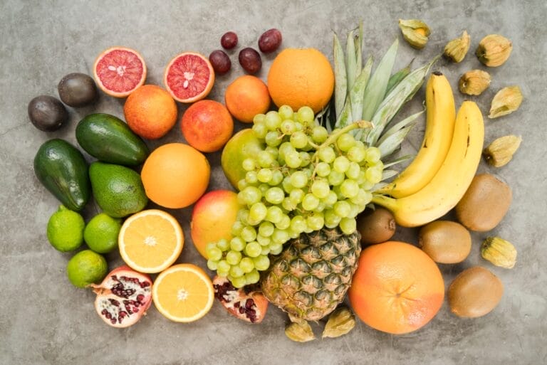 Berbagai jenis buah segar seperti nanas, anggur, jeruk, pisang, alpukat, dan kiwi yang bermanfaat untuk kesehatan ginjal, kaya antioksidan dan vitamin C